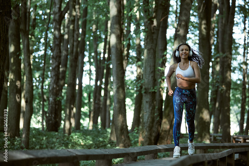 Young girl enjoying outdoors workout - young attractive and fit afro American woman running at countryside road in sport practice concept and healthy lifestyle