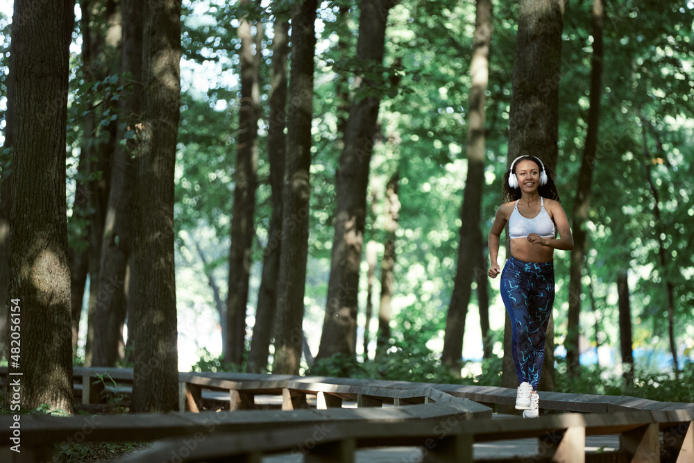 Young girl enjoying outdoors workout - young attractive and fit afro American woman running at countryside road in sport practice concept and healthy lifestyle Young girl enjoying outdoors workout - young attractive and fit afro American woman running at countryside road in sport practice concept and healthy lifestyle