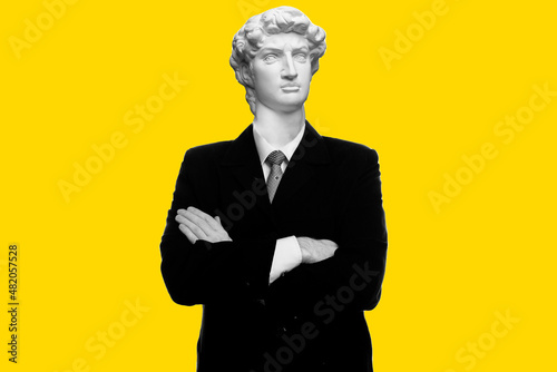 Abstract modern collage. The man with the plaster head of David businessman standing with arms folded isolated on yellow background