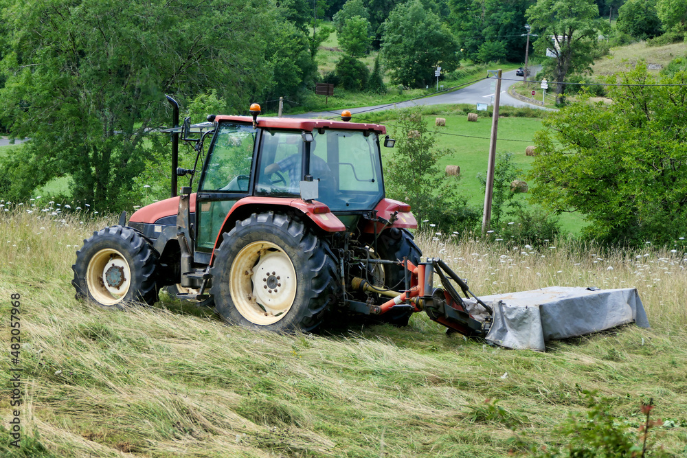 Tractor cutting grass in a field prior to drying and baling
Tractor cutting grass in a field prior to drying and baling