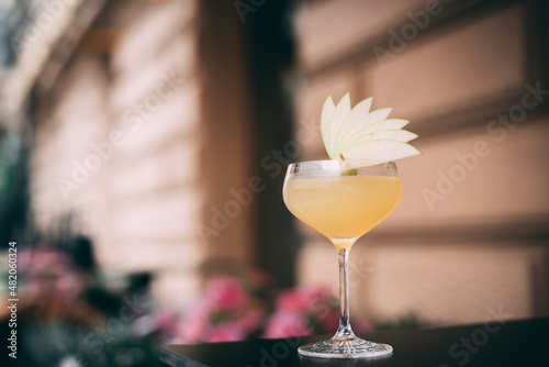 Appletini cocktail served with fresh apple garnishing on the top photo