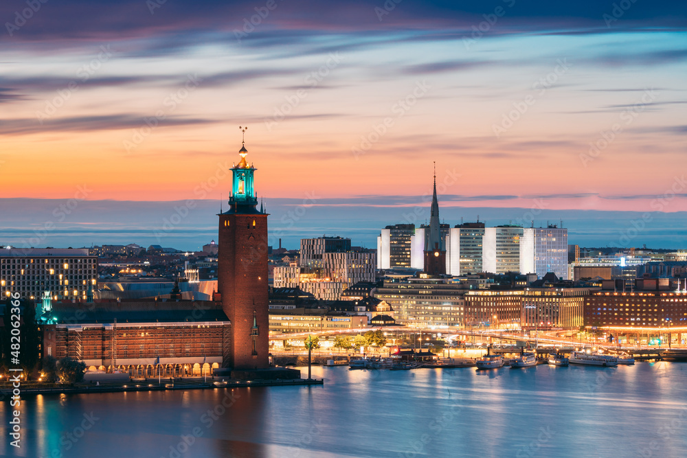 Stockholm, Sweden. Scenic Skyline View Of Famous Tower Of Stockholm City Hall And St. Clara Or Saint Klara Church. Popular Destination Scenic View In Sunset Twilight Dusk Lights. Evening Lighting