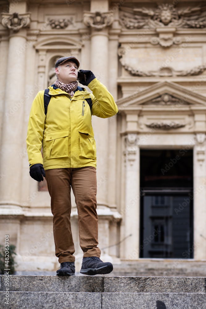 a man in a jacket walks on the stairs through the beautiful streets of the city