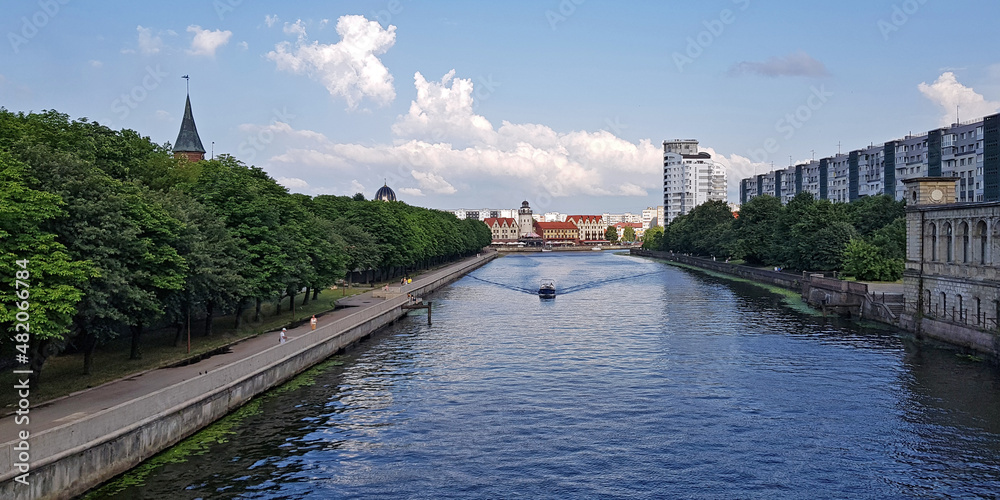 embankment of the river channel with a boat on the background of ancient and modern buildings