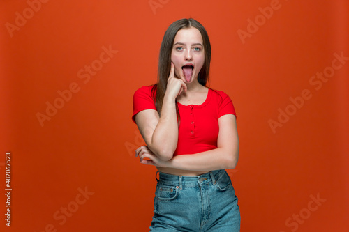 фотографія Cheeky modern young girl showing tongue, teasing, making faces, fooling, grimaci