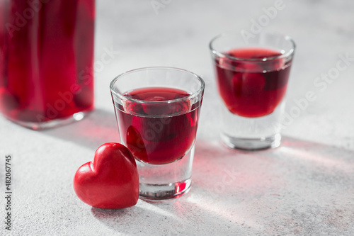 Foto Red cocktail, vodka or liqueur and Heart shape decorations on white background