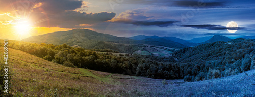 day and night time change concept above carpathian countryside in september at twilight. beautiful mountain landscape with grassy field on rolling hill beneath a sun and full moon. clouds on the sky