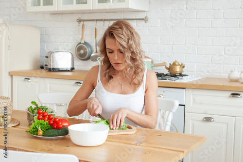 Attractive woman with vegetable in her kitchen. Healthy eating