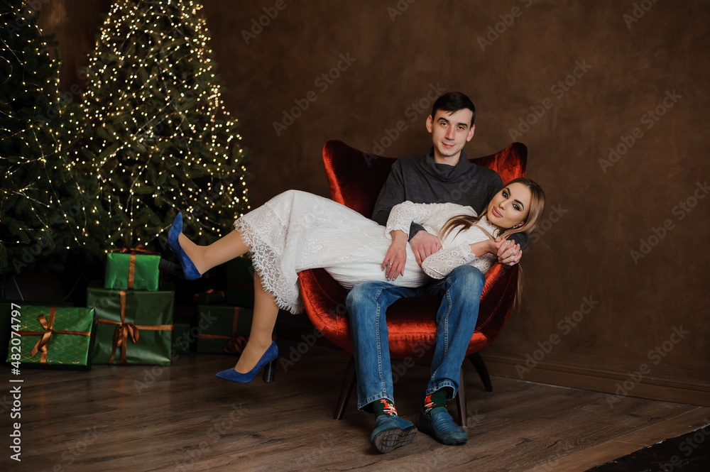 Obraz premium Girl hugging a guy sitting on a red chair