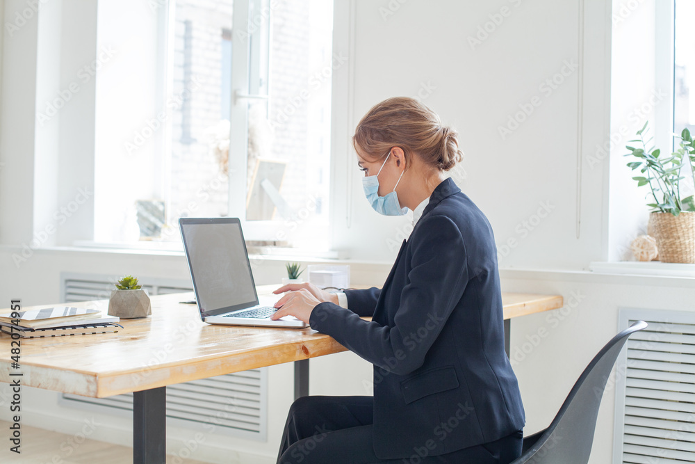 Businesswoman wearing face mask while working on a computer Businesswoman wearing face mask while working on a computer