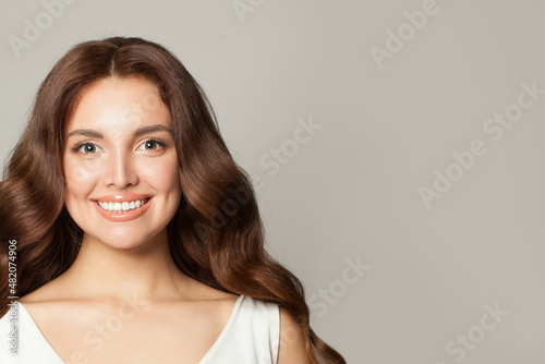 Happy smiling woman with healthy skin, friendly smile and perfect wavy hair portrait