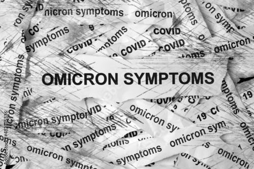 Several strips of paper labeled Omicron symptoms. Coronavirus concept.