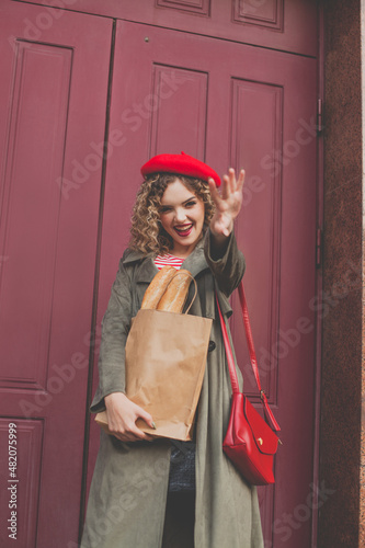 Young woman smiling and saying goodbye in urban background