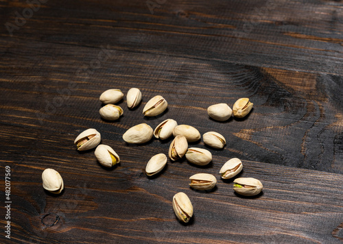 Appetizing pistachio nuts on a wooden background