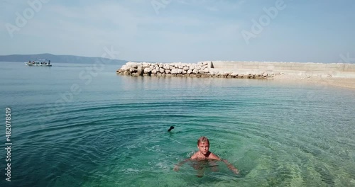 Little boy on a paddleboard.
Cute child learning on a paddleboard. Aerial view.