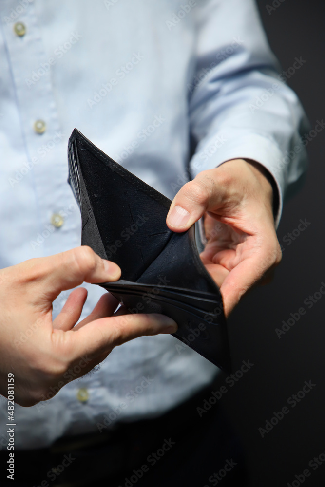 economic crisis. Business Person holding an empty wallet on dark backgruound. Bankruptcy 