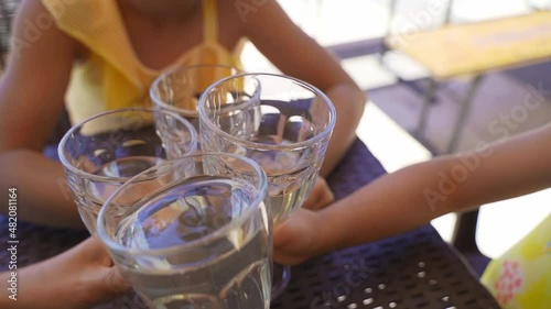 Happy Family with children outdoors on terrace restaurant, clinking glasses. family drinks lemonade, lemon water