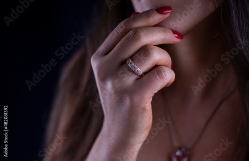 beautiful jewelry accessory gold ring on the hand of a girl with a red manicure