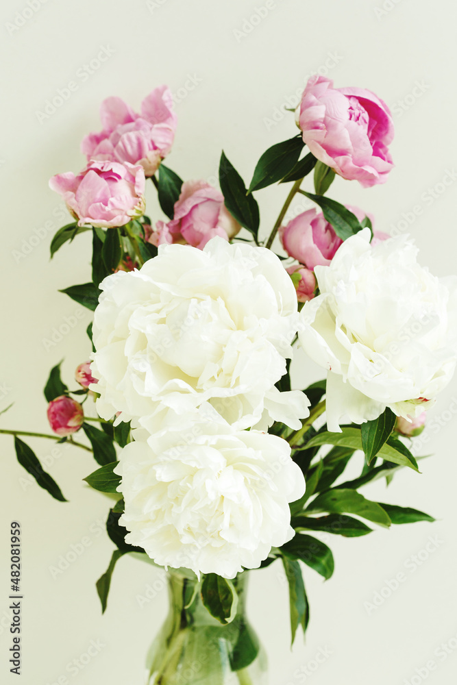 Sloopy flower bouquet of pink and white peonies flowers over pastel background, spring and summer