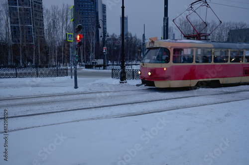 old, red tram rides through the winter city