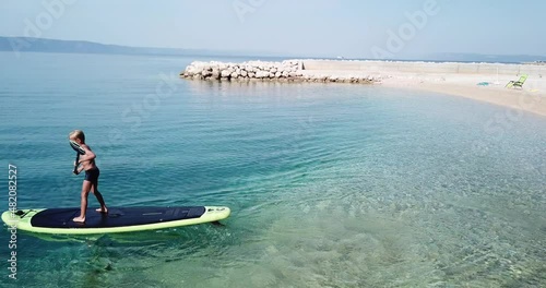 Little boy on a paddleboard.
Cute child learning on a paddleboard. Aerial view.