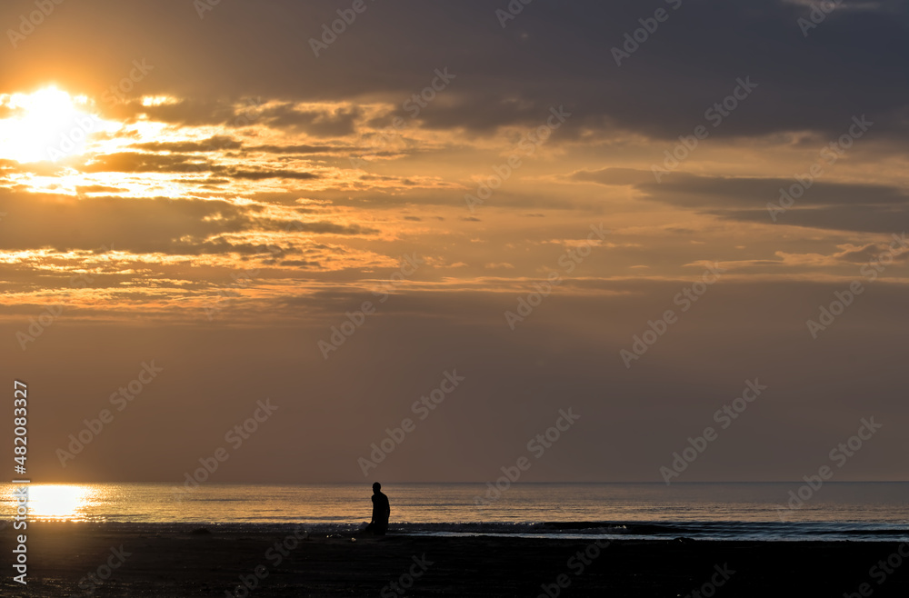 Sunrise on a foggy morning on the Black Sea coast. Beautiful seascape, early sunrise at sea and picturesque sky. Small waves and horizon line. Odessa Oblast, Ukraine.