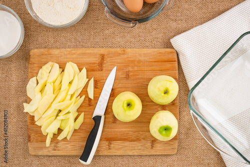 Apple slices close up on a wooden boardon rustic background. Apple cake with biscuit base recipe, step by step baking process photo