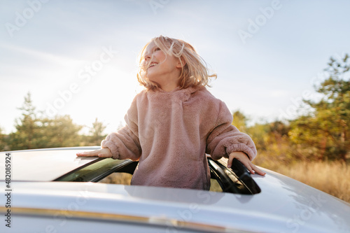 Cute girl in sunroof of car photo