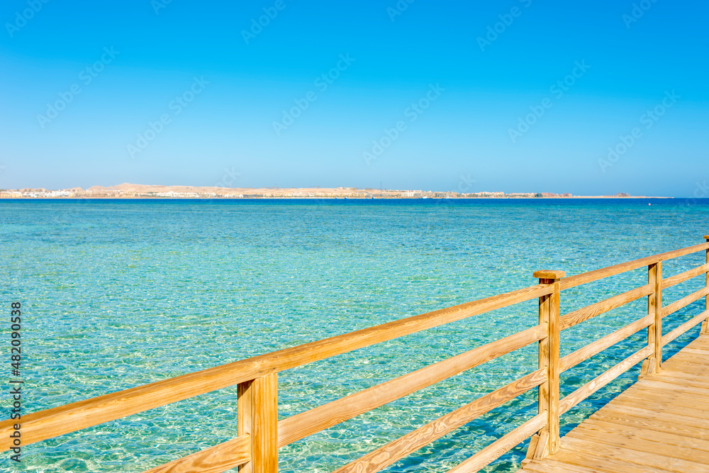 wooden pier against blue sky and turquoise sea on a sunny day in egypt, sahl hasheesh wooden pier against blue sky and turquoise sea on a sunny day in egypt, sahl hasheesh