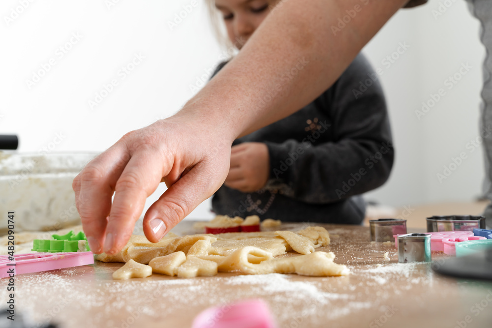 Father feeling playful with his caucasian little daughter, while preparing homemade dough for tasty cookies. Father and his child spending time at home 