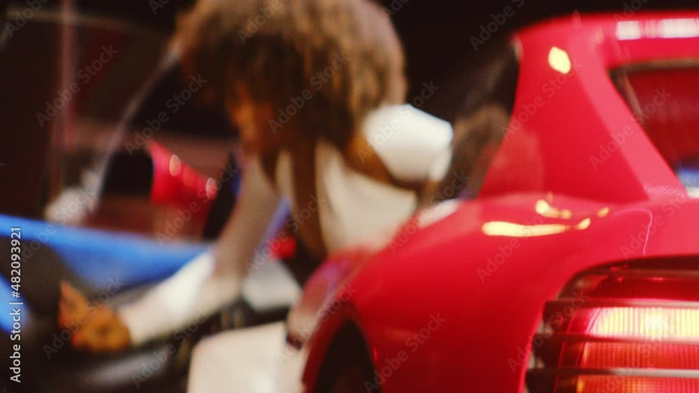 Woman With Afro Getting Out Of Driver's Seat Of Red Car