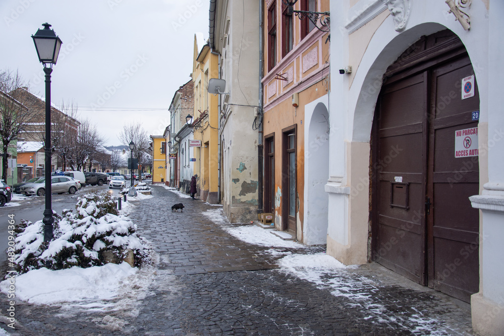  Evangelical Church Tower  in Bistrita , january 2022,and the flag of Romania ,view from Nicolae  Titulescu street