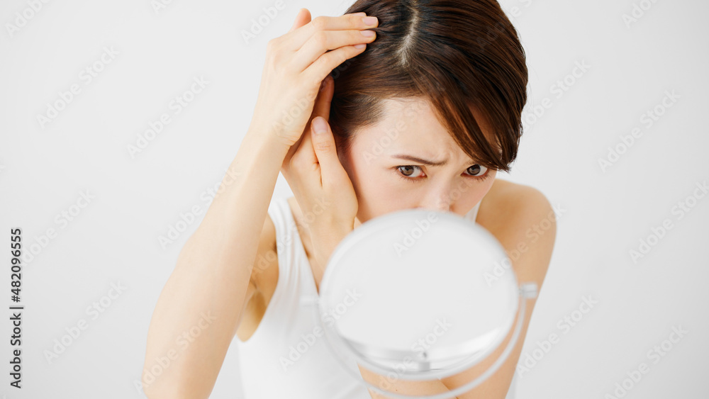 ヘアケアをする若い女性 ヘアケアをする若い女性