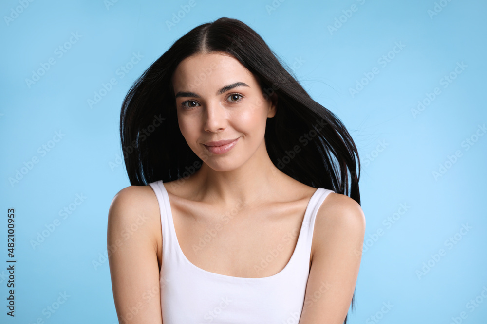 Portrait of beautiful woman on light blue background