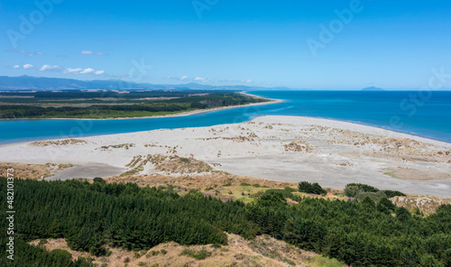 the mouth of the manawatu river as it enters the Tasman Sea at Foxton Beach. Looking south  kapiti island in the distance and the tararua ranges to the east