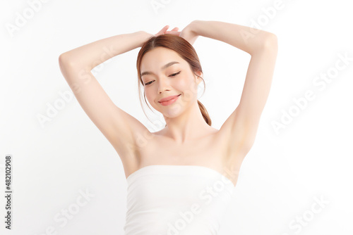 Beautiful Young Asian woman lifting hands up to show off clean and hygienic armpits or underarms on white background, Smooth armpit cleanliness and protection concept © kitthanes