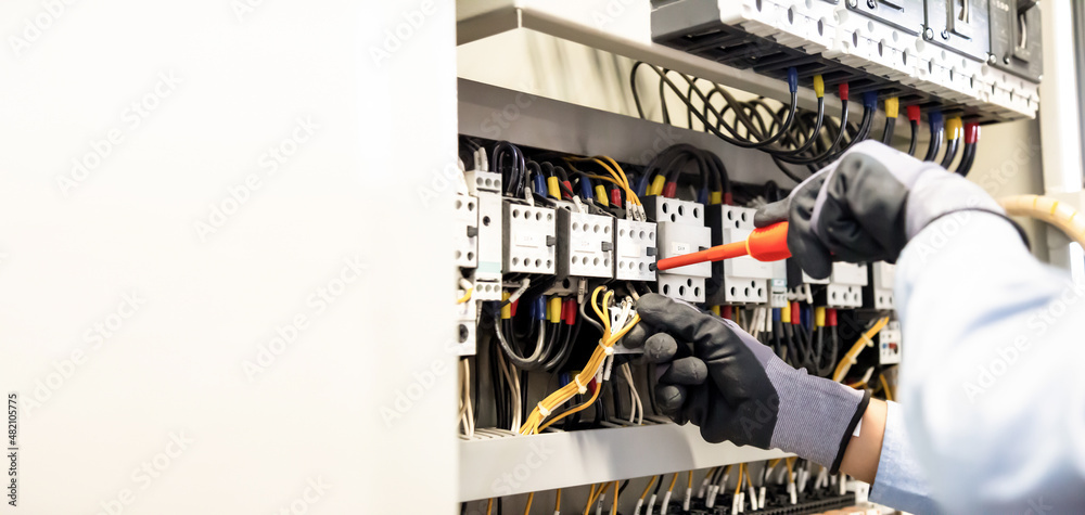 Electricians work to connect electric wires in the system, switchboard ...