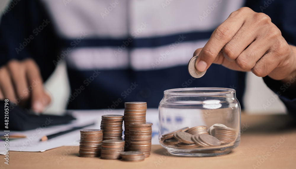 Businessman holding coins putting in glass. concept saving money for finance accounting.