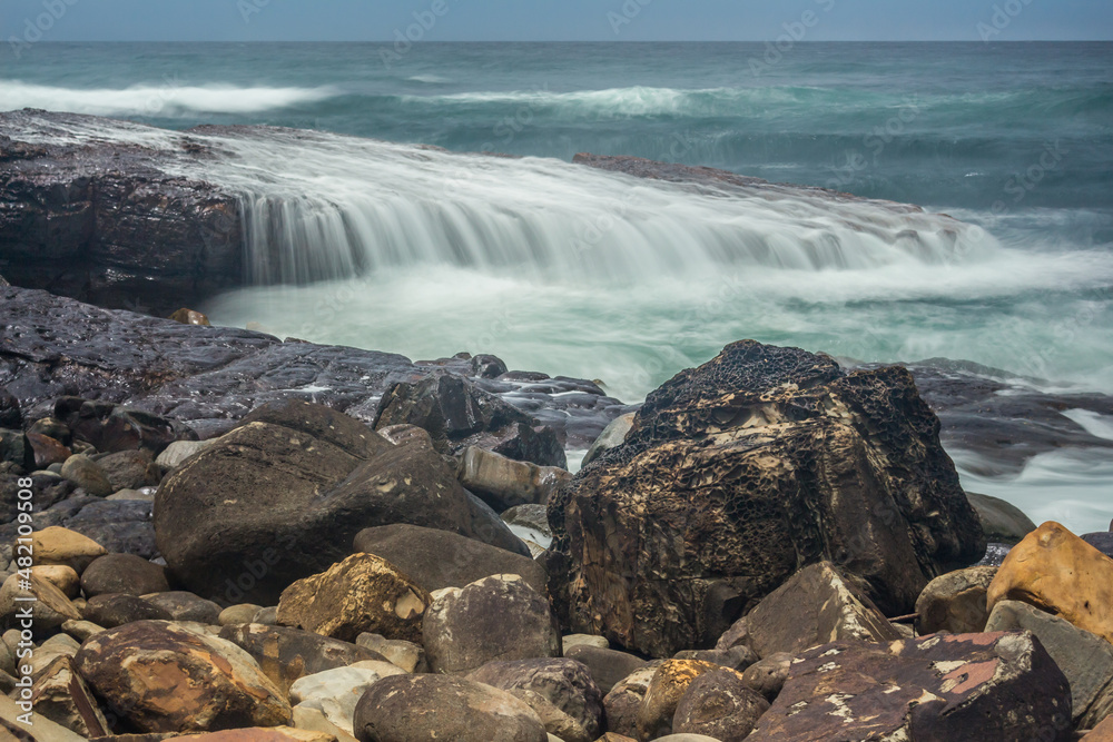 ocean wave cascade over rock shelf - long exposure ocean wave cascade over rock shelf - long exposure
