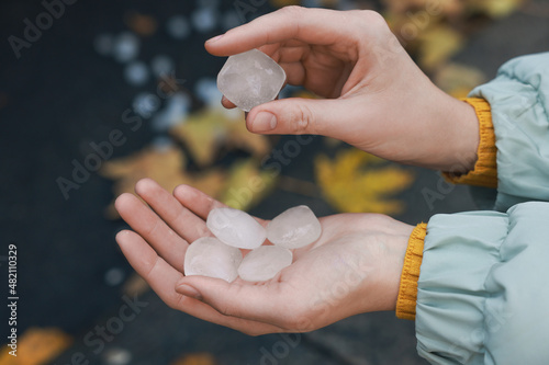 Fotografie Woman holding hail grains after thunderstorm outdoors, closeup