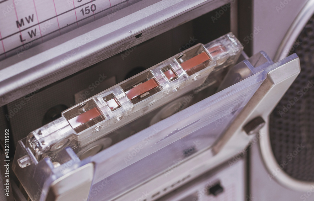 An audio cassette with a magnetic tape is in an old tape recorder An audio cassette with a magnetic tape is in an old tape recorder