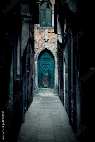 Narrow alley with Teal door at the end in Italy
