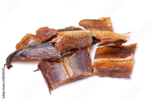 Pieces of salted dried fish with spices isolated on a white background