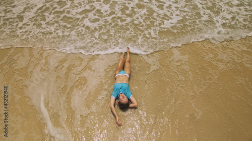 Woman lying on shallow water sea. Happy slightly tipsy woman enj photo