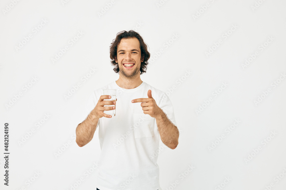 Attractive man glass of water in his hands emotions posing isolated background Attractive man glass of water in his hands emotions posing isolated background