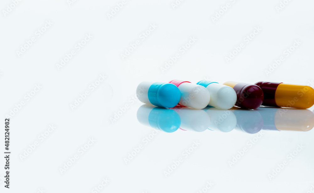 Antibiotic capsule pills on white background. Prescription drugs. Colorful capsule pills. Antibiotic drug resistance concept. Pharmaceutical industry. Superbug problems. Medicament and pharmacology. Antibiotic capsule pills on white background. Prescription drugs. Colorful capsule pills. Antibiotic drug resistance concept. Pharmaceutical industry. Superbug problems. Medicament and pharmacology.