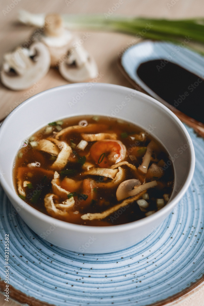 Homemade asian spicy soup style with soy sauce and mushrooms champignons and big prawn Homemade asian spicy soup style with soy sauce and mushrooms champignons and big prawn