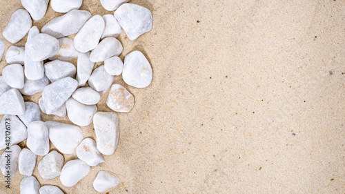Decorative small white stone pebbles on the sand. Background, texture, copyspace
