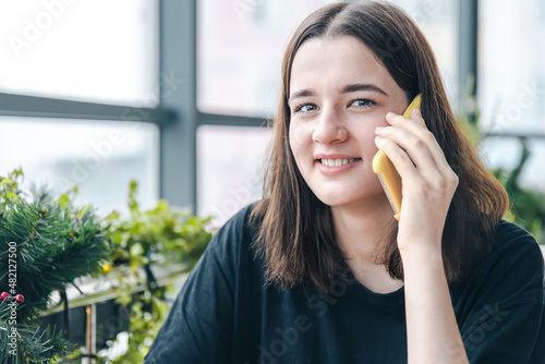 Portrait of a smiling young woman talking on the phone.