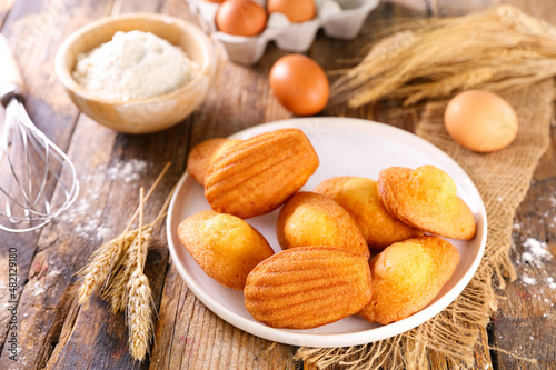 madeleine cake and ingredient on wood background photo